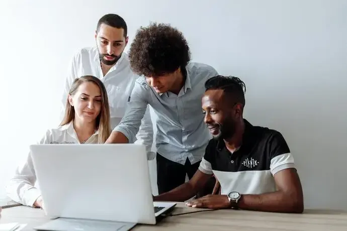 Group planning business deliveries while looking at laptop