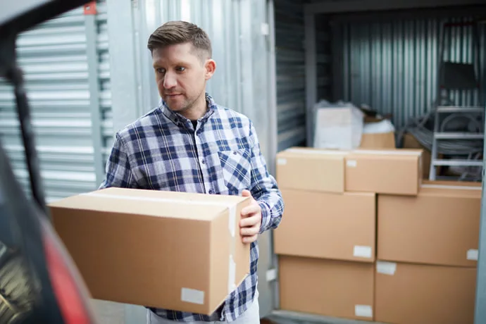 Customer carrying boxes off a delivery vehicle