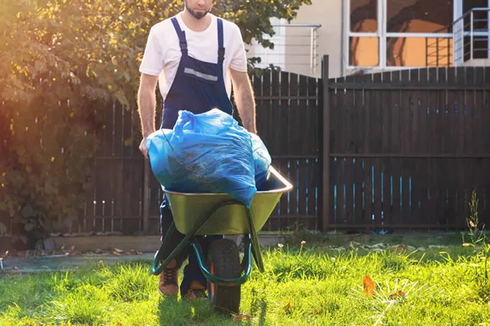 Customer pushing a wheelbarrow full of grass